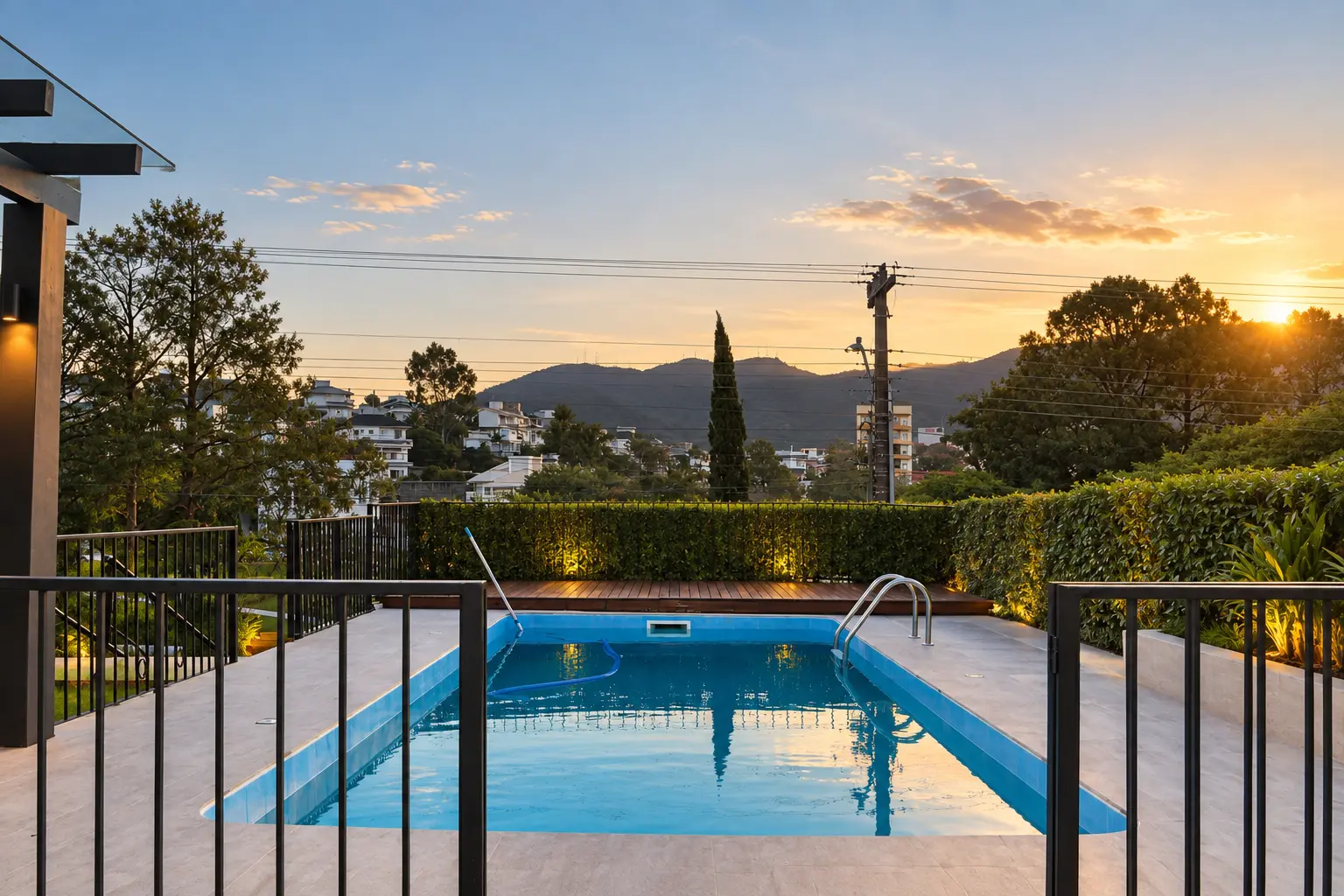 Área da piscina depois da reforma, com deck, pergolado e paisagismo